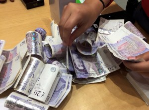 Hands counting £20 notes