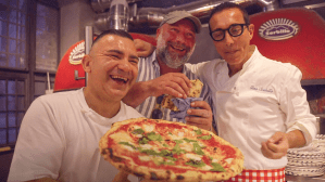 Three male pizza chefs in Naples, known as pizzaoli, laugh as they show off the delicacy for which the Italian city is known